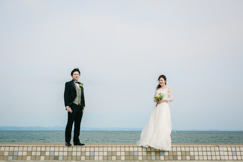 海をバックに。