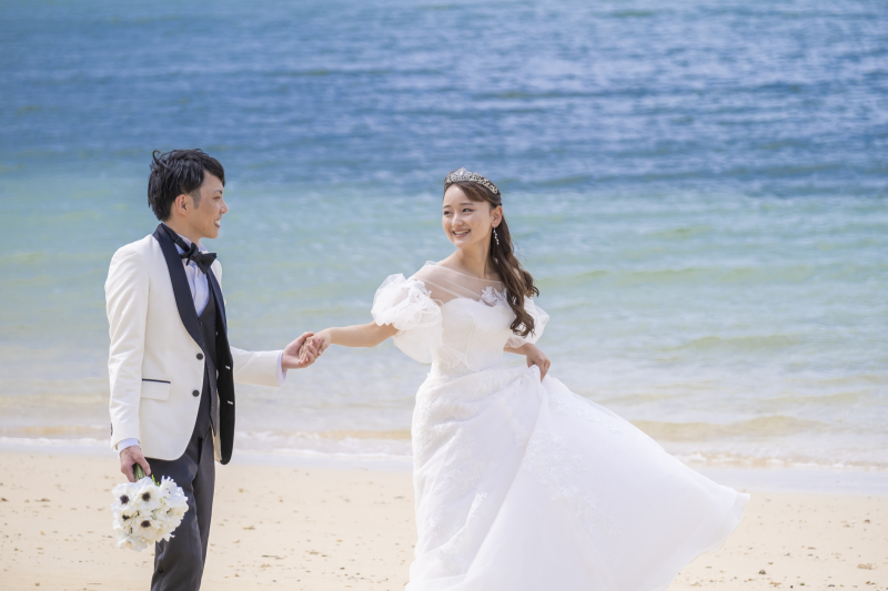 手を繋ぎ、砂浜をふたりで歩む、ゆったりとした時間