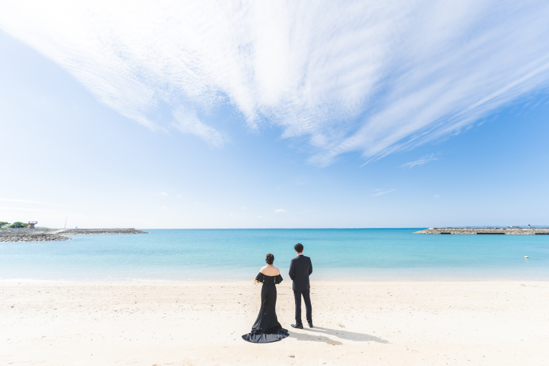 沖縄の青空とエメラルドグリーンの海を背に誓う背中