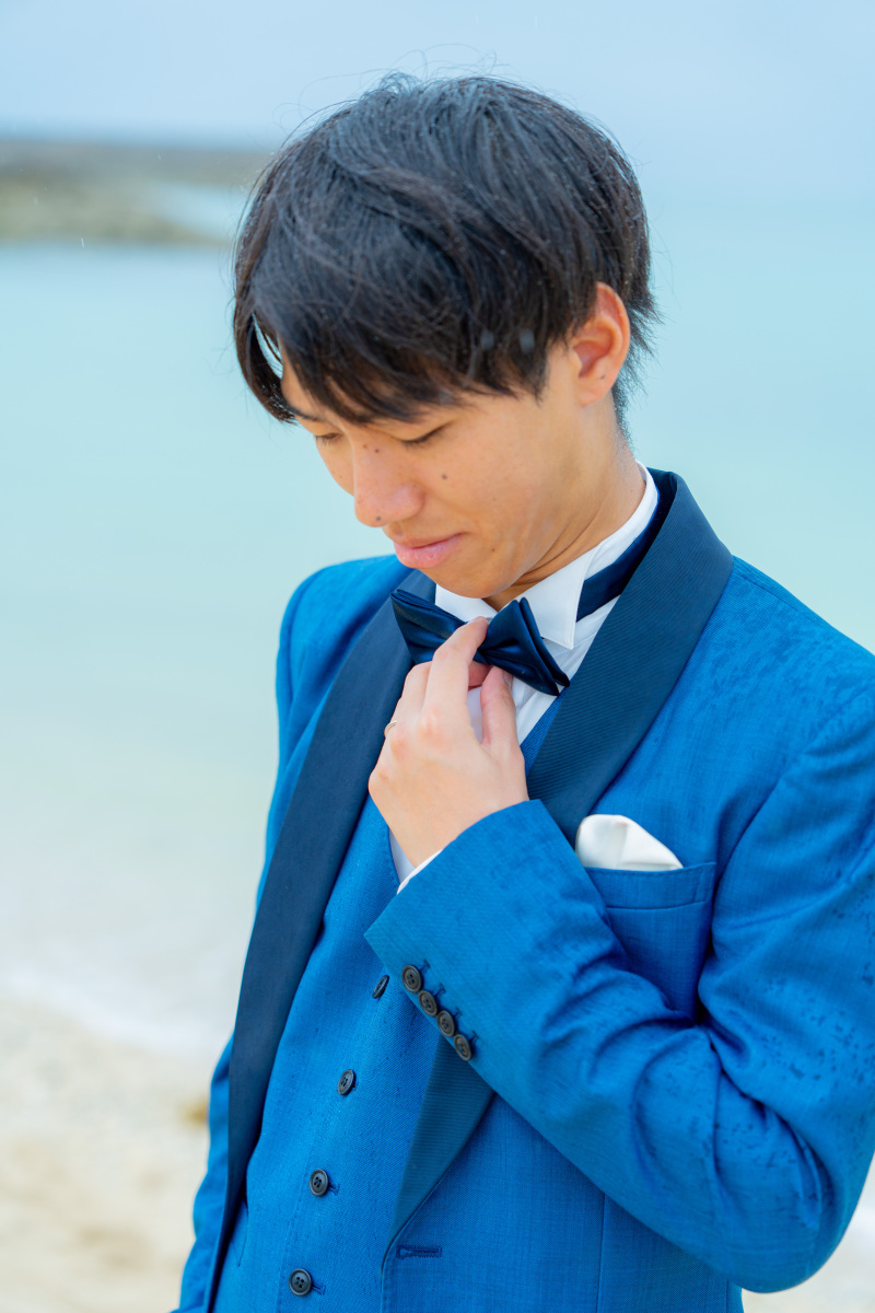 蝶ネクタイを整える姿がクールなご新郎ソロカット。
