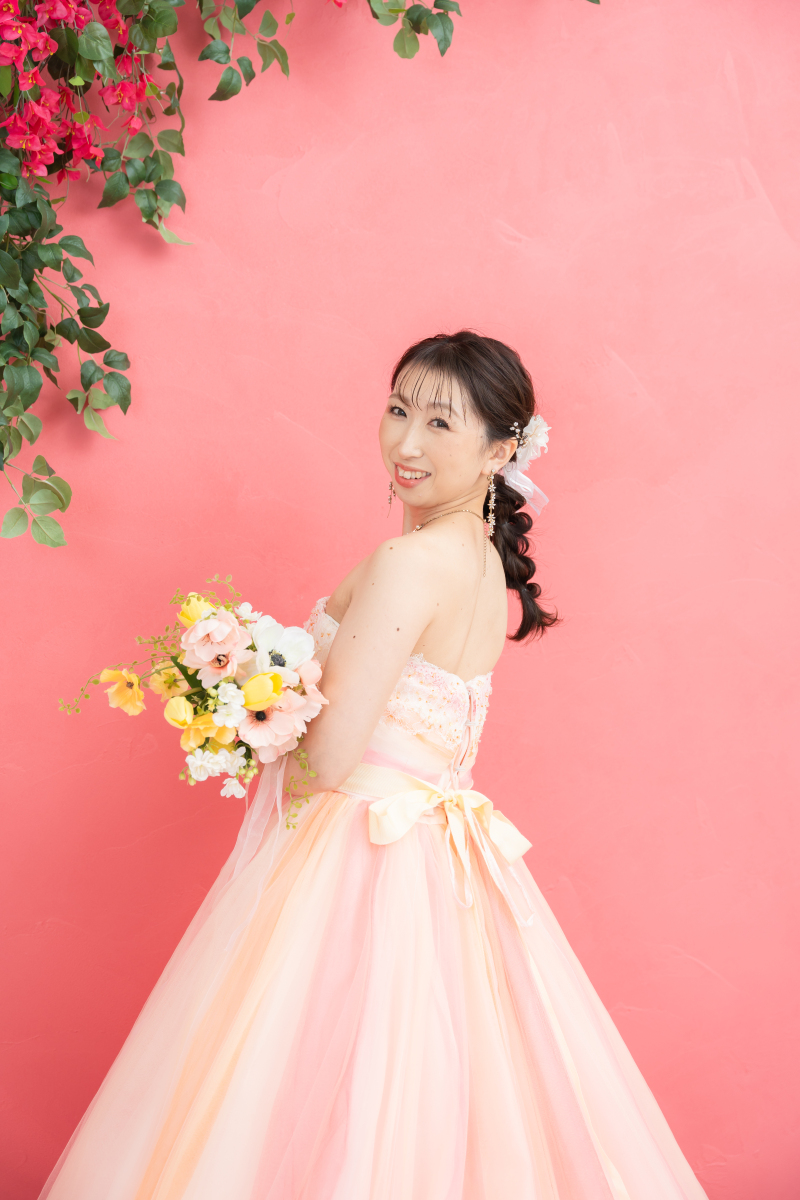 ピンク色の背景に映える素敵な笑顔