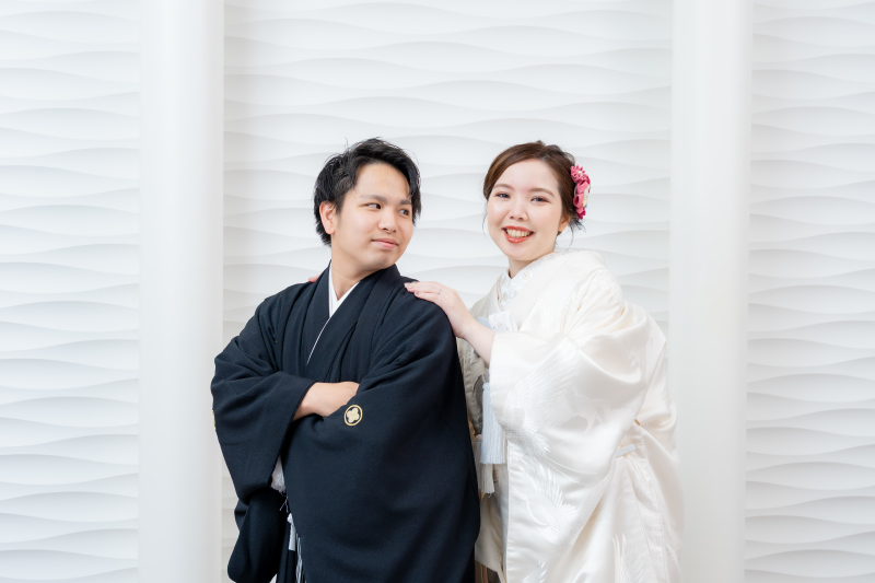 新郎様の肩にそっと手を添えて微笑む新婦様の姿です