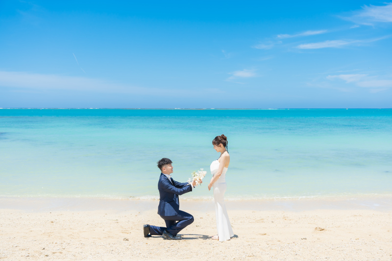 白い砂浜でひざまずいてブーケを渡すプロポーズ♡