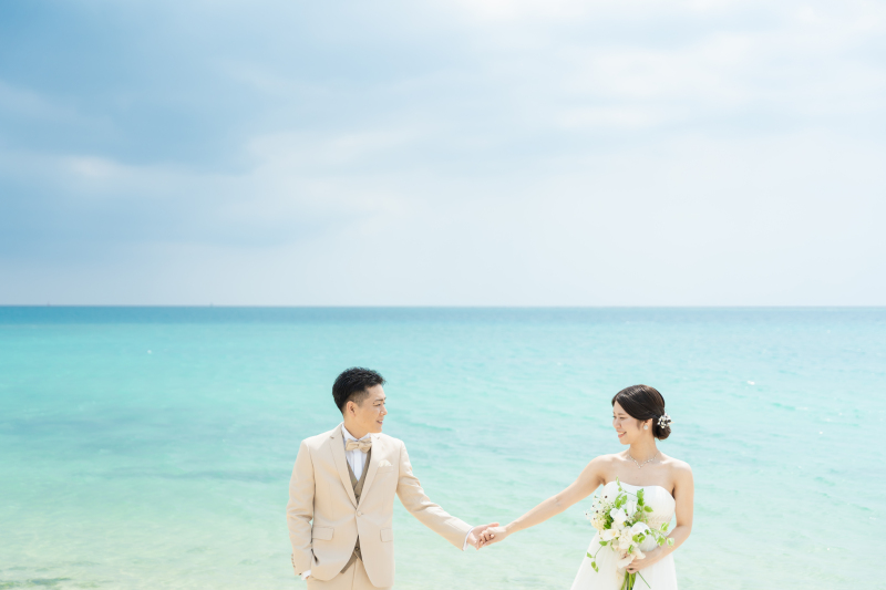 エメラルドグリーンの海で見つめ合うおふたりの笑顔