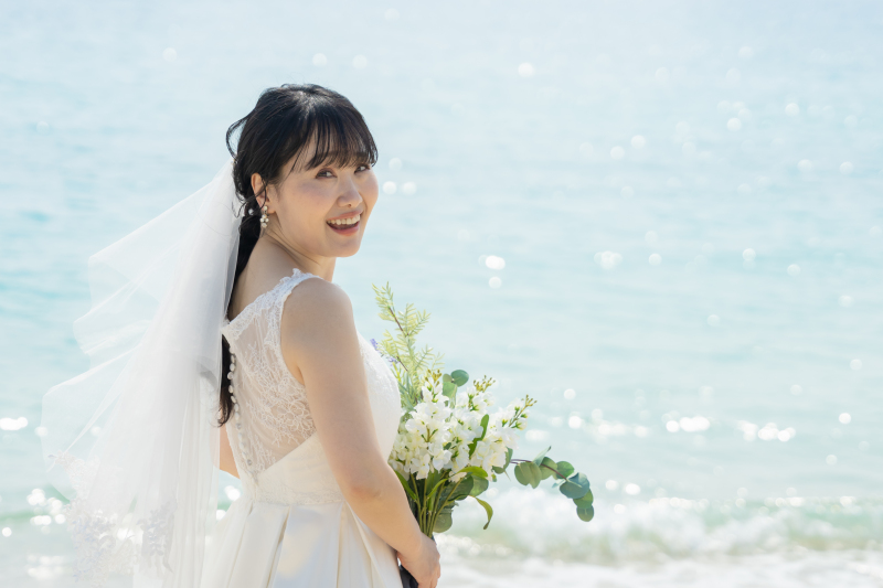 光り輝く海をバックに微笑む新婦様の美しいソロ姿!