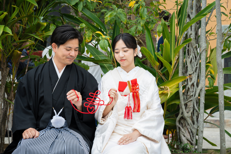 赤い糸のアイテムを手に、寄り添い見つめ合うお二人