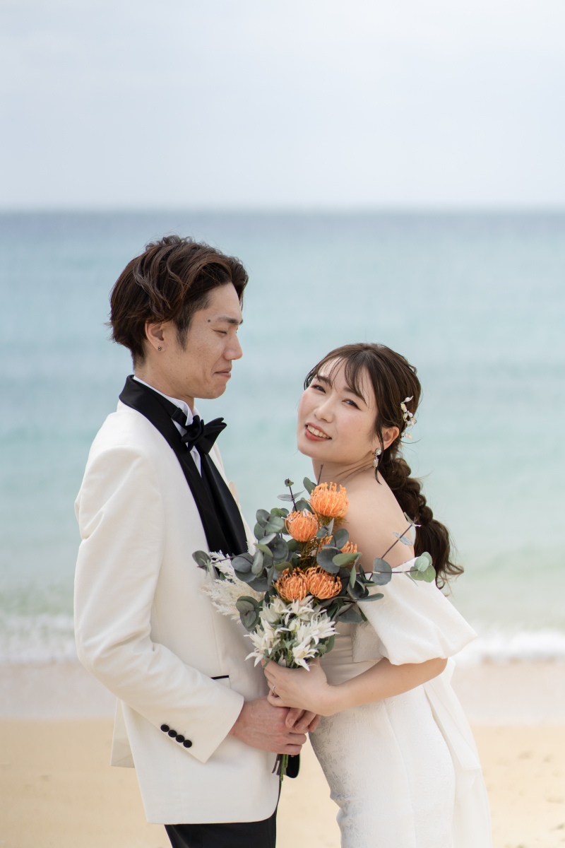 エメラルドの海を背に、寄り添い合うパパとママ