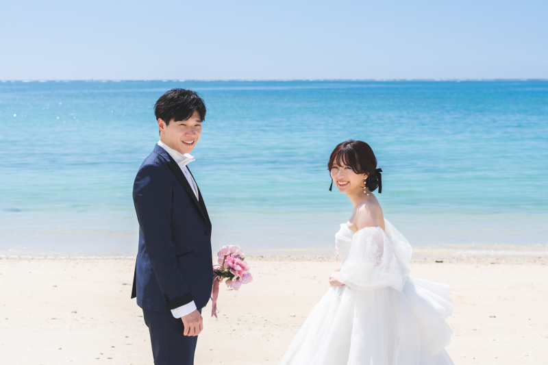 どこまでも続く海を背景に、自然体の笑顔を残して