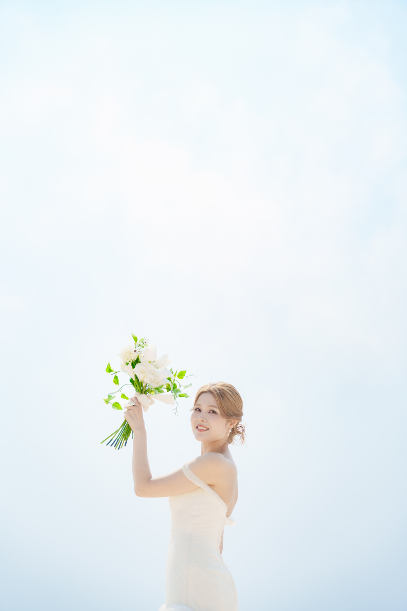 空に掲げた花束。幸せいっぱいの笑顔輝くソロカット