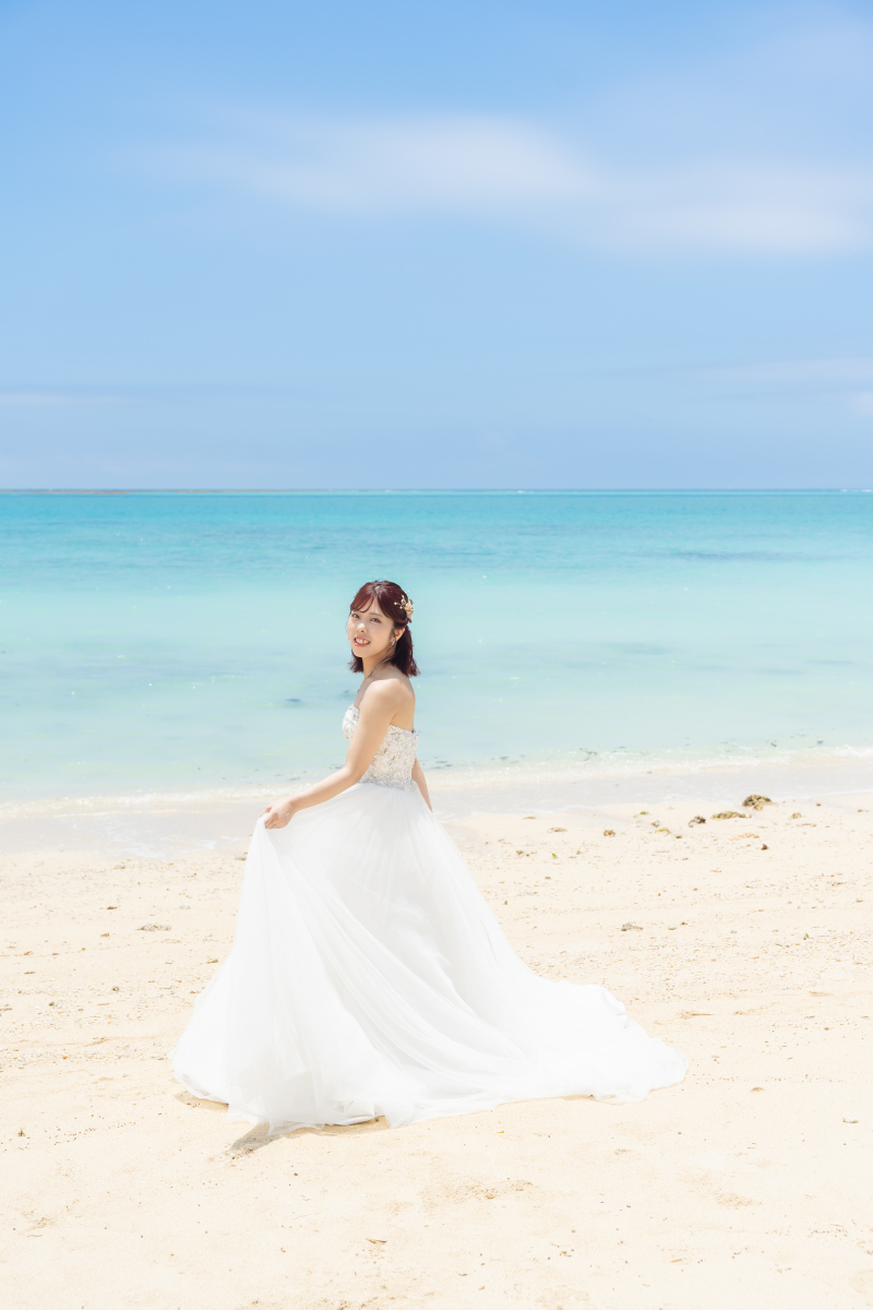 白い砂浜で振り返って微笑む新婦様の美しいソロ姿！