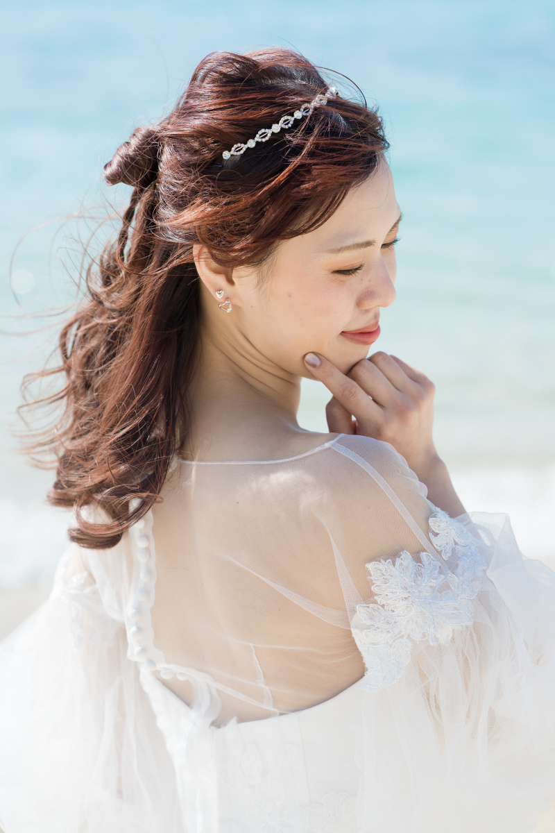 風に揺れる髪と微笑み。美しき花嫁のバックショット