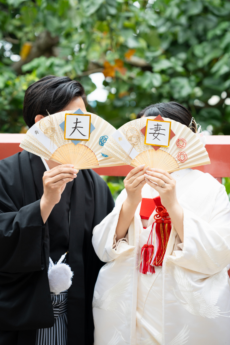 夫と妻の扇子を広げて。お顔を隠したお茶目なポーズ