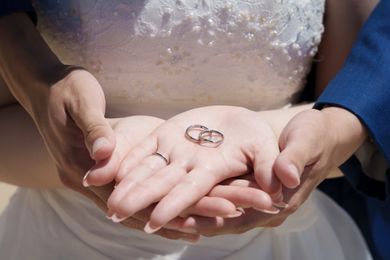 重なる手に託す誓い。光を吸い込み輝く二つの輪