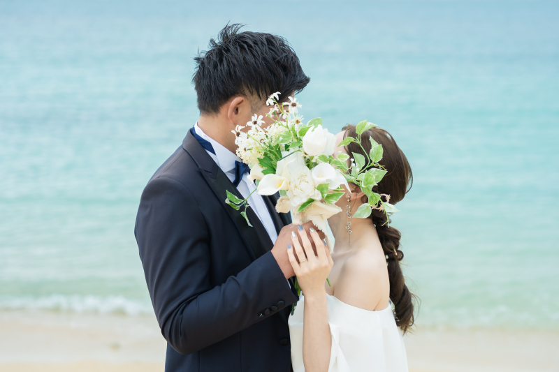 ブーケで顔を隠して寄り添うふたりのおしゃれな一枚
