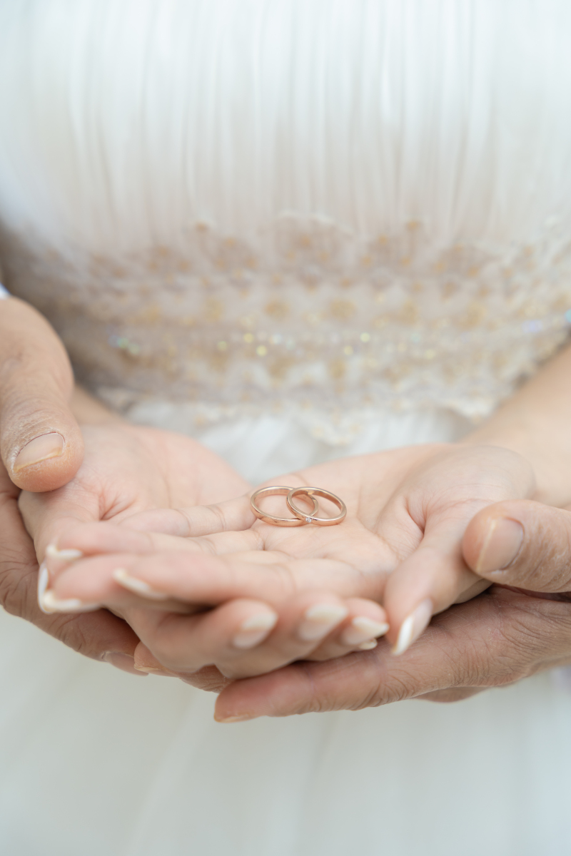 優しく包む手のひらに並べたふたりの大切な結婚指輪