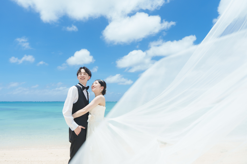 風に舞うロングベールと輝く笑顔の元で約束を交わす