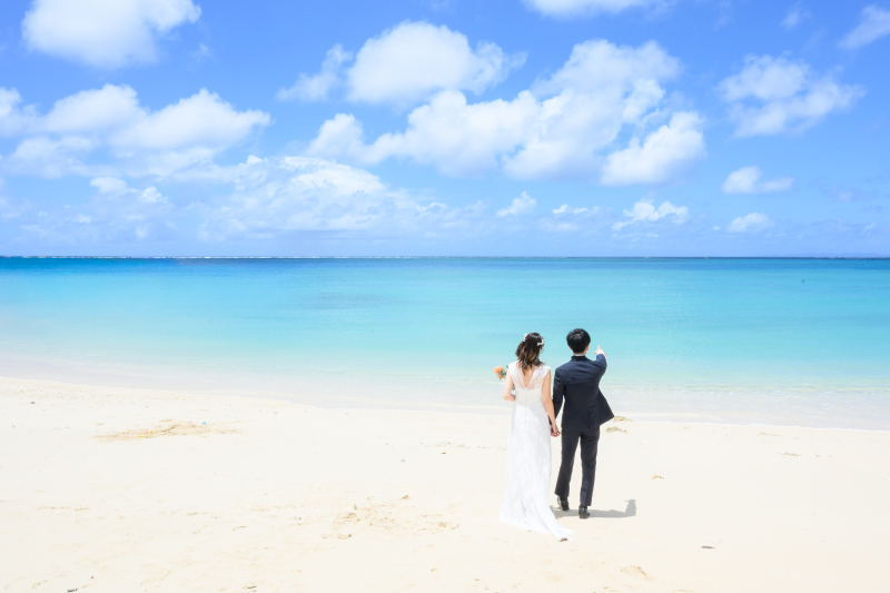 青い海へ向かって歩く、二人の後ろ姿