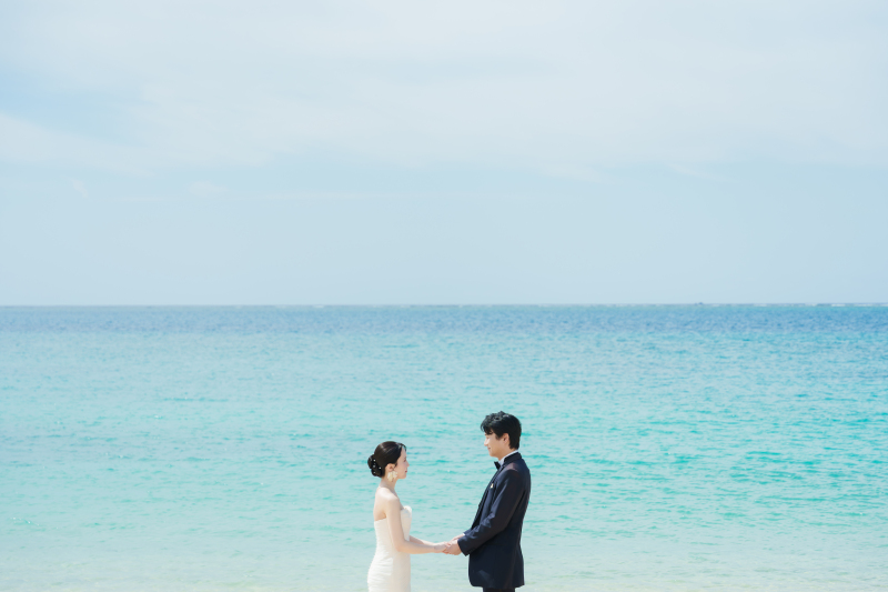 青い海を背に誓う、はじまりを感じるビーチショット