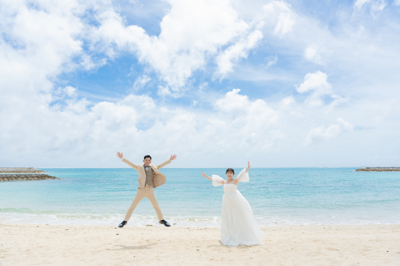 白い砂浜で大きくジャンプする元気いっぱいなカット
