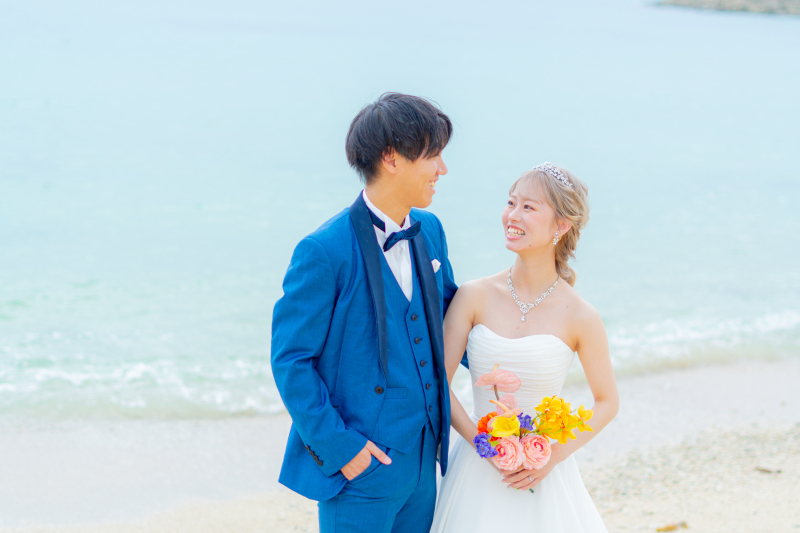 青い海を背にお二人で見つめ合う爽やかな笑顔