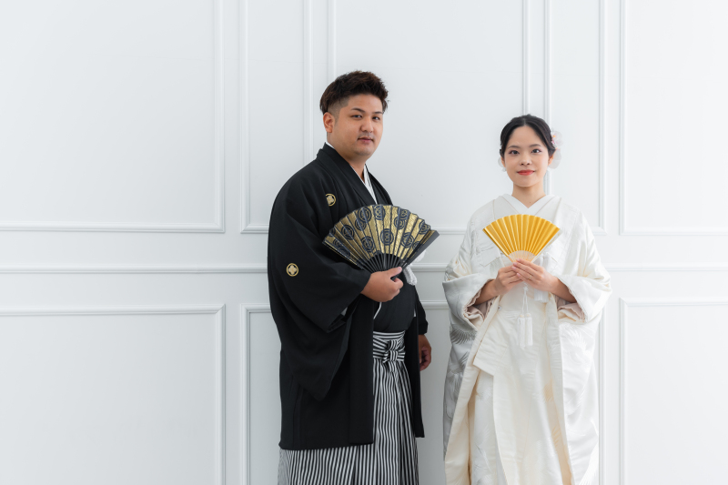 金と黒の扇子がアクセント。華やかさを添える立ち姿