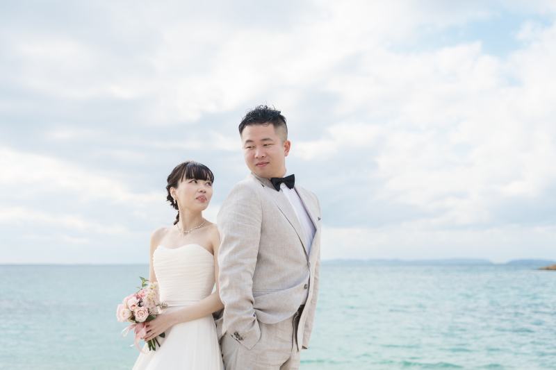 広大な海を背に、背中合わせで見つめ合うお洒落な姿