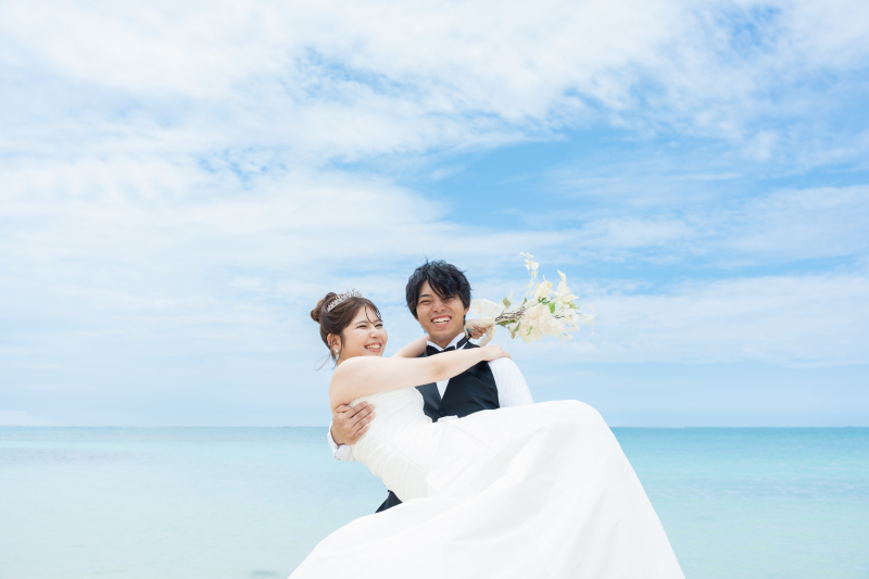 青い海を背景に笑顔が弾ける幸せなだっこショット!