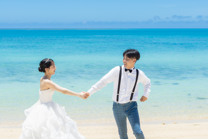 手を繋いで白い砂浜を歩く自然体な笑顔が素敵です！