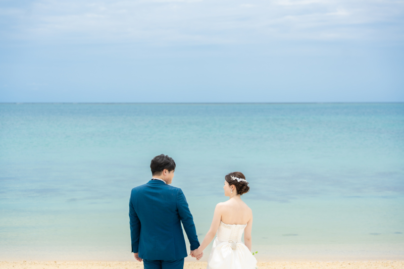 青い海を前に見つめ合うおふたりのロマンチックな姿