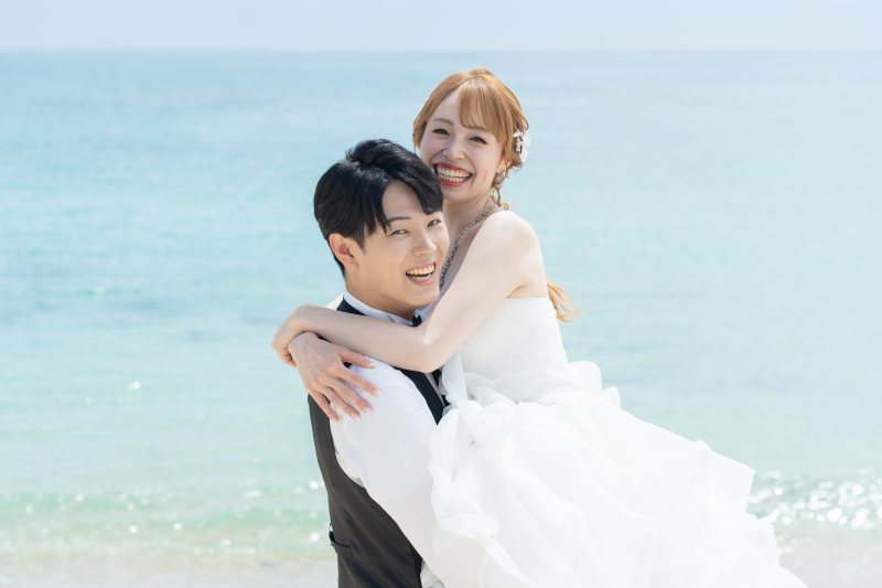 青い海を背景に笑顔が弾ける幸せなだっこショット!