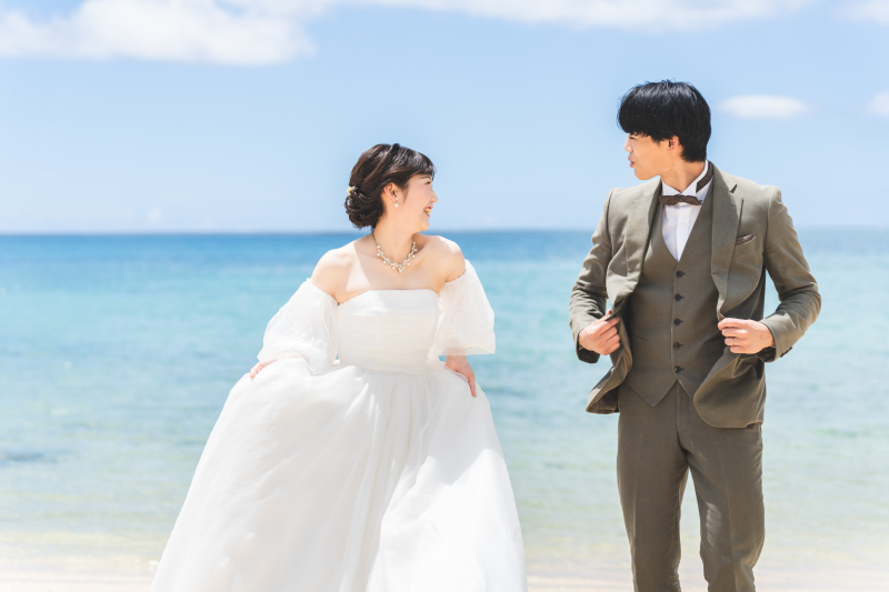 浜辺を仲良く歩きながら自然な笑顔が溢れ出す瞬間