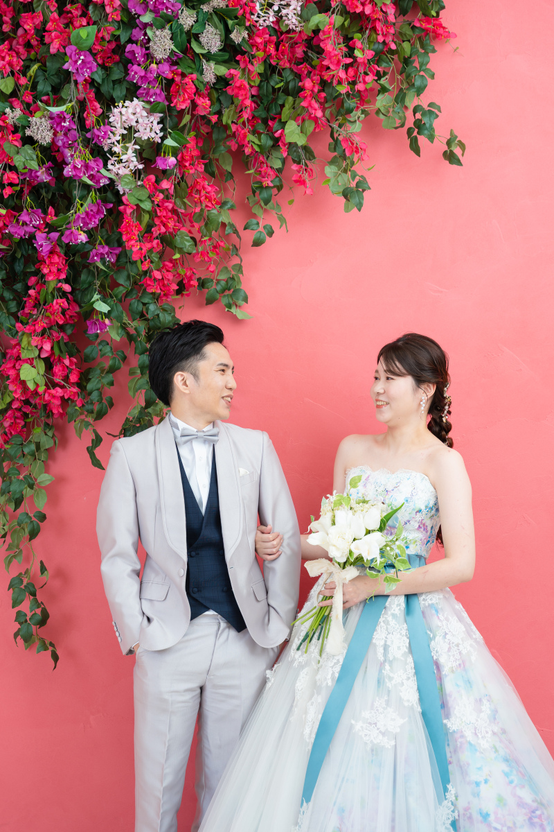 ピンクの壁に咲く花と、見つめ合う二人の幸福な温度