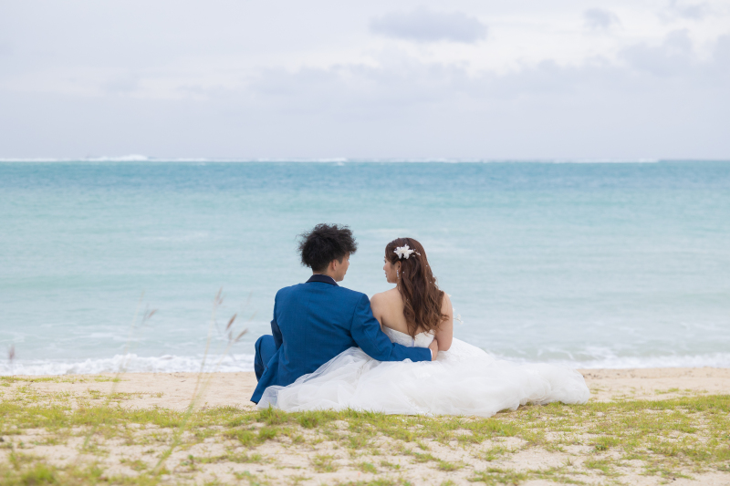 穏やかな海を見つめて。砂浜に寄り添い座る後ろ姿。