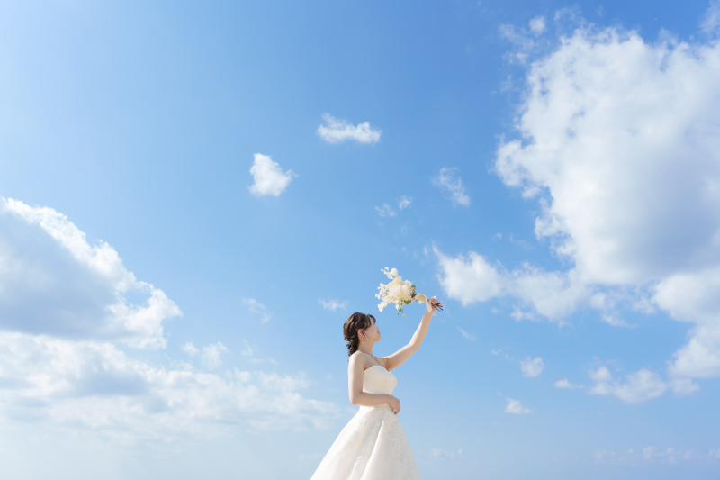 高く掲げたブーケと青空の下で風と波の音を感じて。