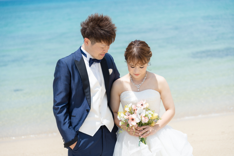 ブーケを見つめる新婦様と優しく寄り添う新郎様の姿