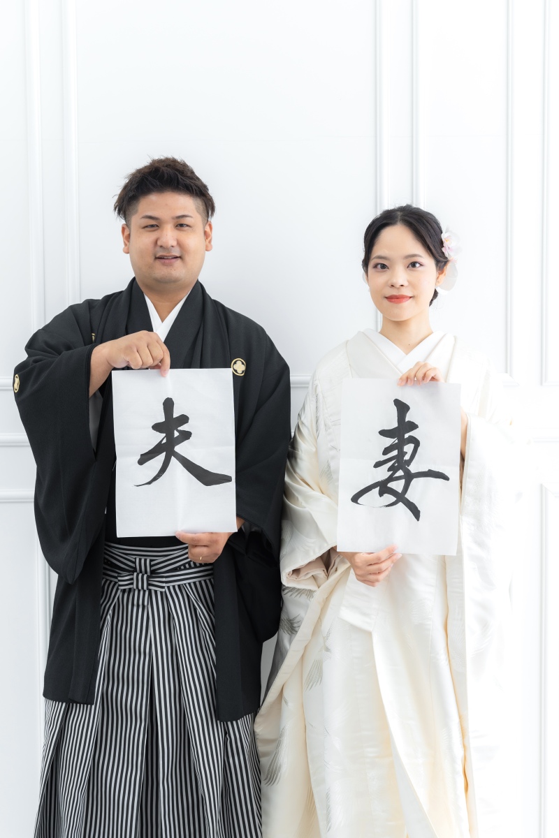 シンプルな背景映える、書を持った凛とした立ち姿。