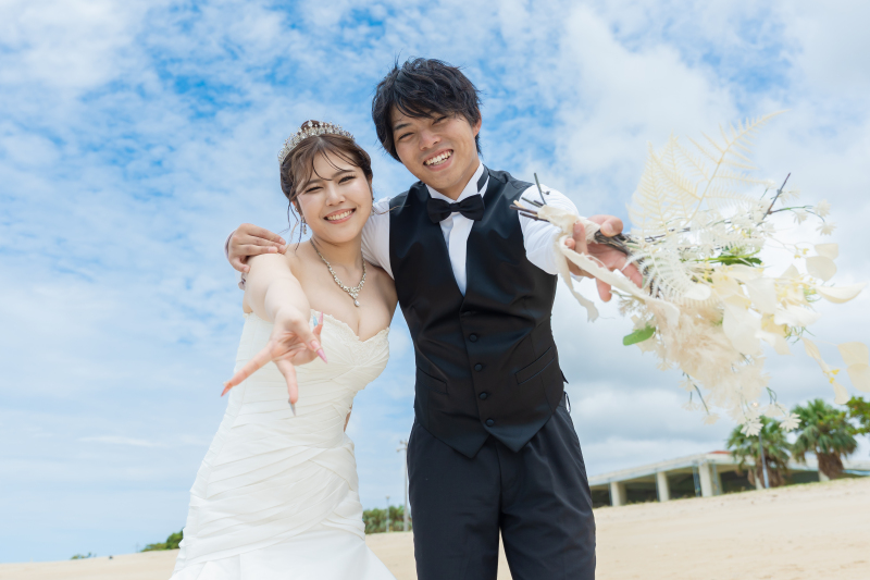 カメラにブーケを向けて元気いっぱいにピースサイン