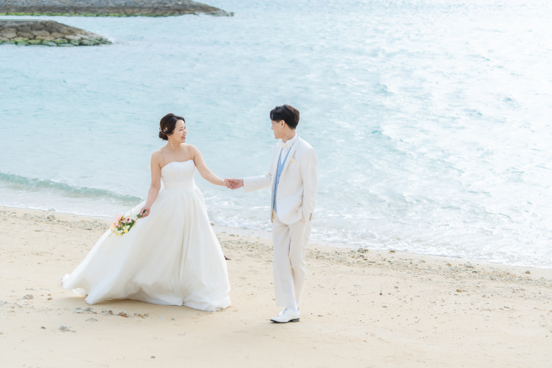 エメラルドの海をバックに歩く幸せなふたり