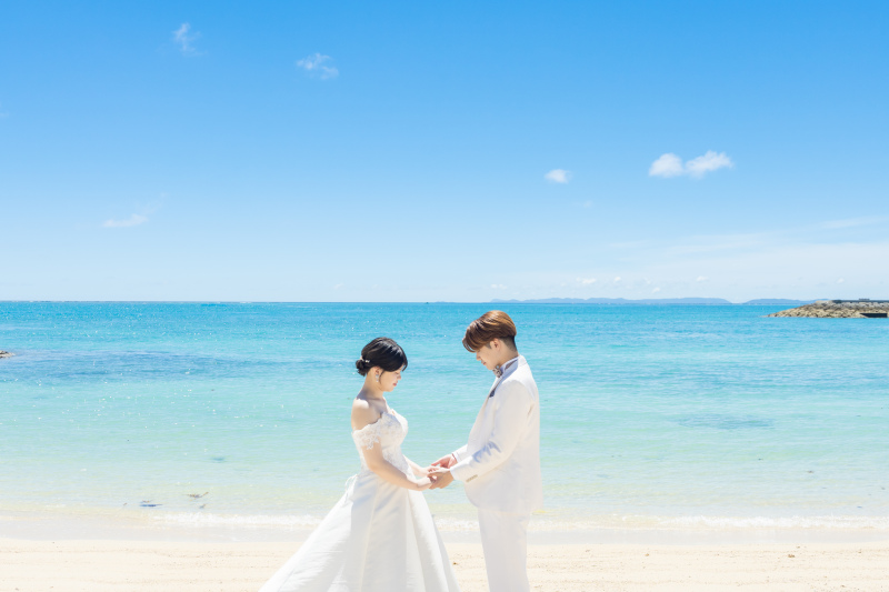 澄み渡る青空とエメラルドの海を前に見つめ合うお姿