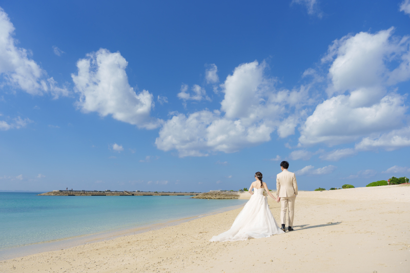 未来へ続く足跡。広い砂浜をどこまでも二人で歩んで