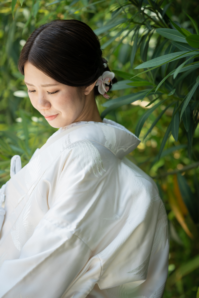 鶴の刺繍が映える白無垢姿で優美な表情を見せる新婦