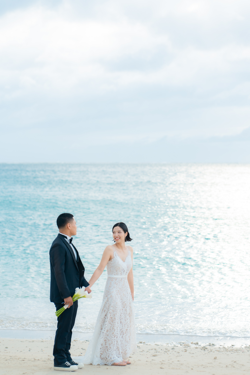 きらめく海を背景に手を取り歩む爽やかなワンシーン