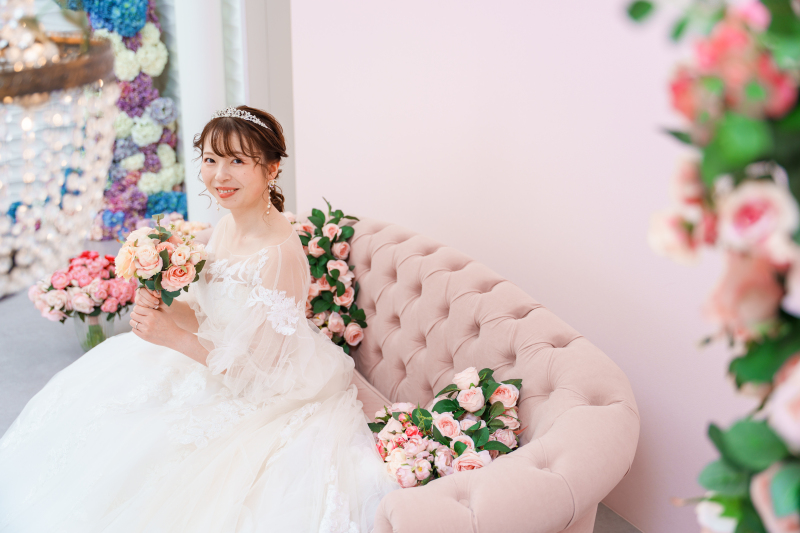 ソファと花に囲まれた優雅な雰囲気の花嫁ソロカット