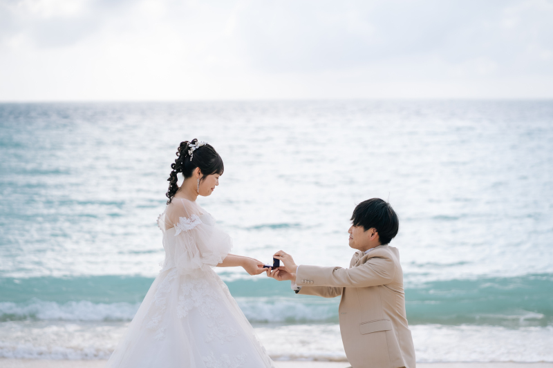 指輪を手に、はじまりを刻むビーチセレモニーの一枚