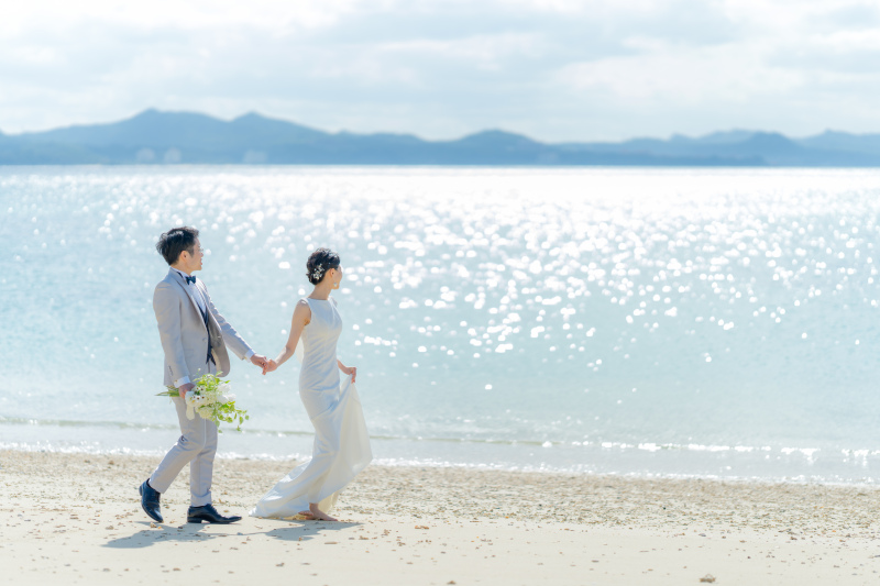 きらきらと輝く水面が美しい海をバックにおふたりのナチュラルな姿を撮影