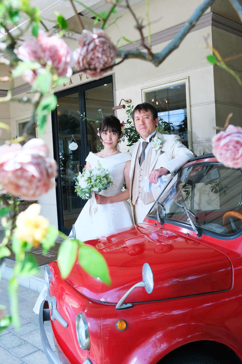 赤い車とピンクのバラと