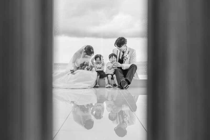 見慣れないチャペルの中でもいつも通りの「家族4人の時間」を。新郎新婦としてだけではなく、「パパ・ママ」としても特別な時間を一枚に残しました。家族の空気感を崩さないために、ドアの向こうからこっそりと。