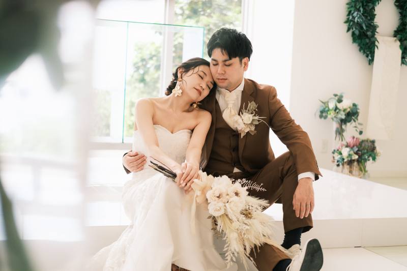 真っ白なチャペル、ピンク色のお花、青いビーチ