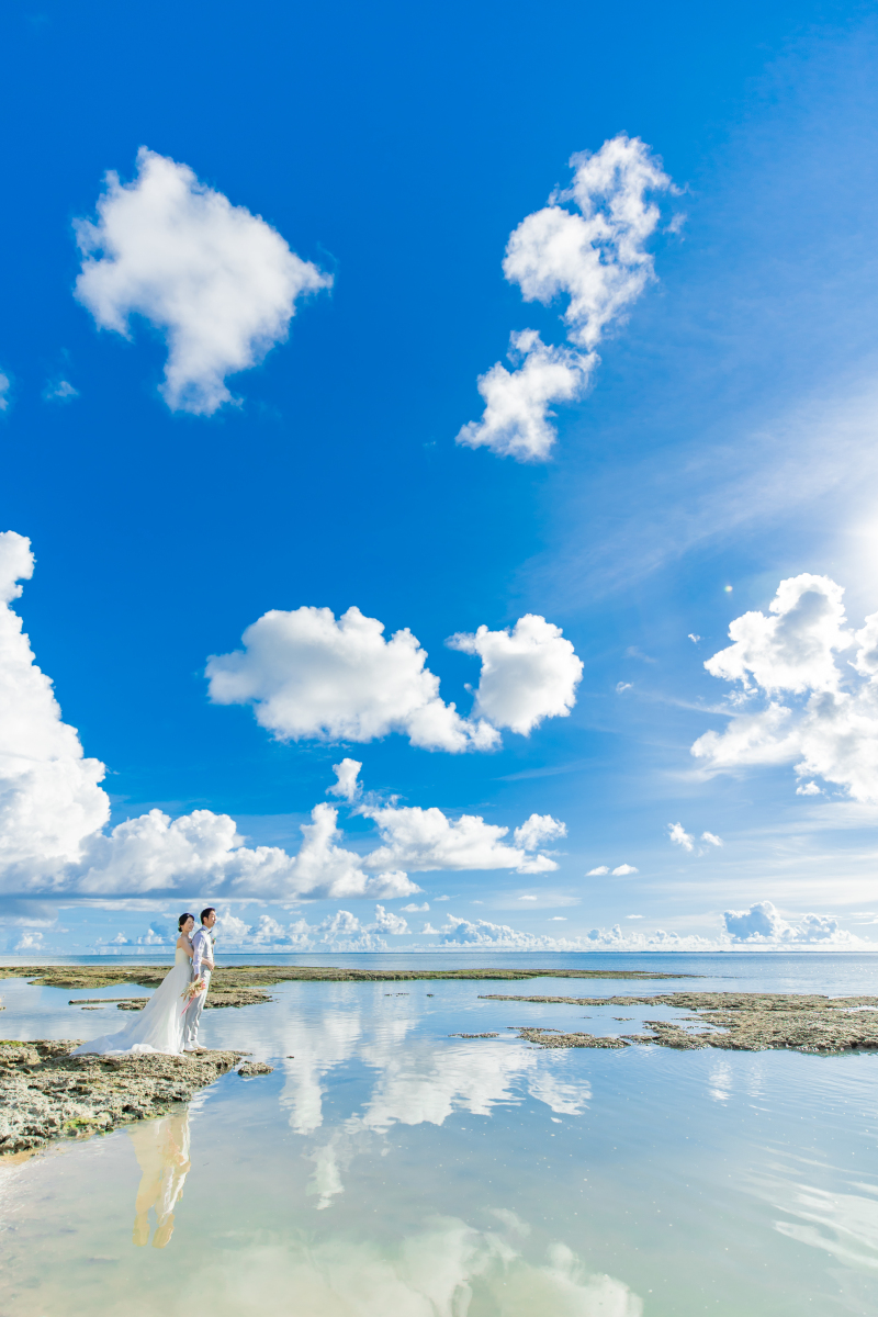 風がやんだ一瞬のシャッターチャンスも逃しません！空とおふたりの姿が海に映り込んだ感動的な奇跡の1枚も、沖縄のロケーションを知り尽くしているからこそ叶えられます。