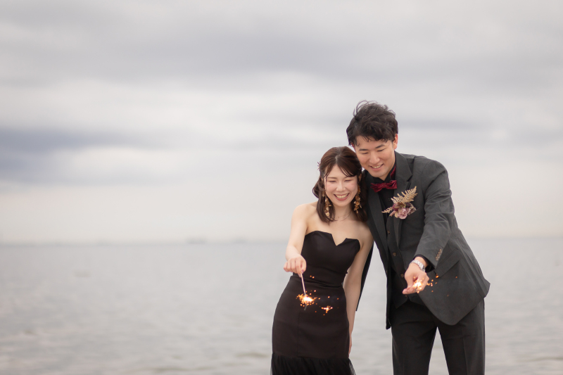 海辺で手持ち花火、笑顔で